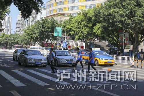 四川警察學(xué)院前的斑馬線沒有紅綠燈，但過往車輛見到有行人過斑馬線都會(huì)禮讓行人